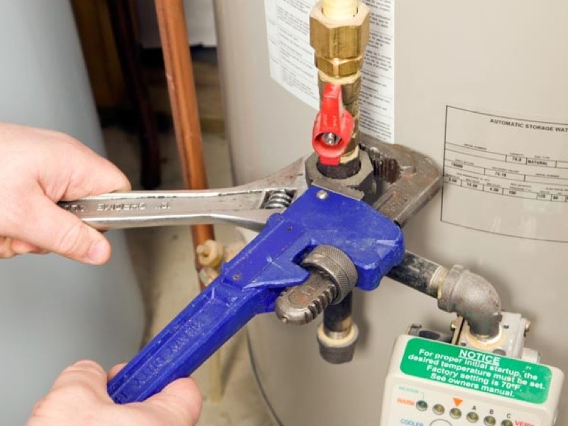 Plumber repairing water heater plumbing connections in Naperville, IL 
