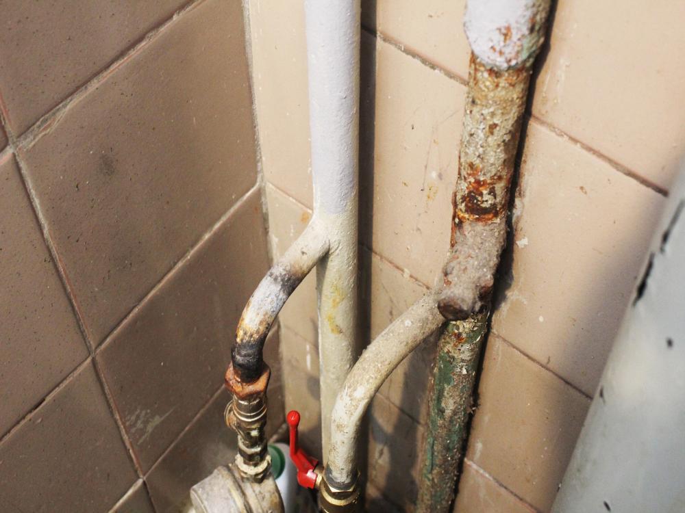 Corroded and rusty water pipes inside an apartment building