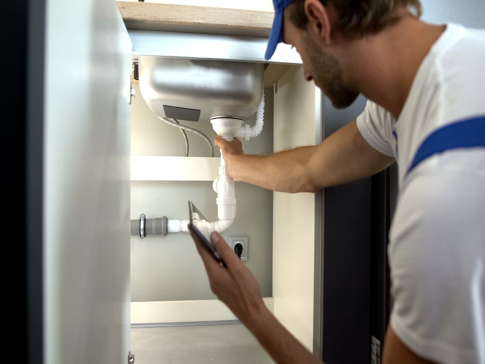 Professional plumber inspecting residential water pipes